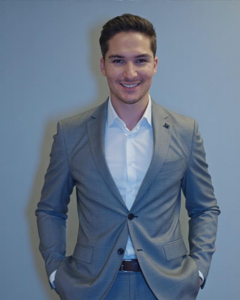 Professional young man in a suit smiling for digital marketing image.